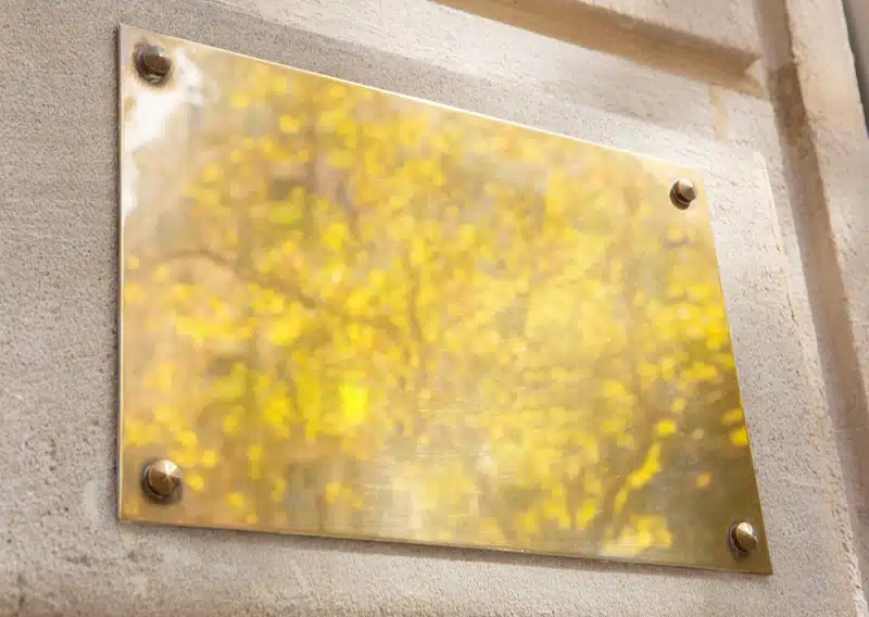 Plaque professionnelle en métal fixer sur un mur