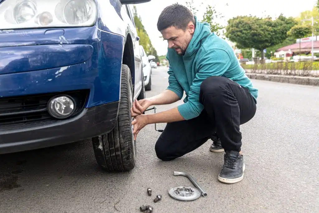 homme assurer au tiers change lui même la roue crevé de sa voiture